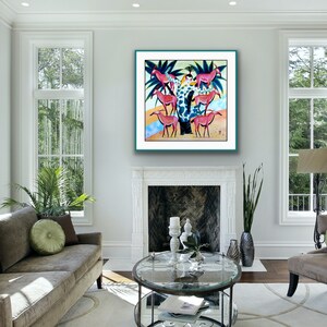 May include: A colorful painting of a woman in a green and white patterned dress standing on a tree trunk surrounded by pink and white deer. The painting is framed in a teal frame and hanging on a white wall.
