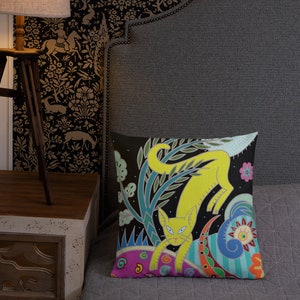 Peut inclure: Un chat jaune avec des motifs floraux verts, bleus et roses sur un fond noir. Le chat est assis sur un cercle &agrave; motifs roses et bleus.