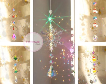 Puede incluir: Cuatro atrapasoles de cristal diferentes con varios diseños navideños. Los atrapasoles presentan un copo de nieve, un árbol de Navidad y dos figuras de Papá Noel. Cada atrapasol tiene un prisma de cristal en la parte inferior.
