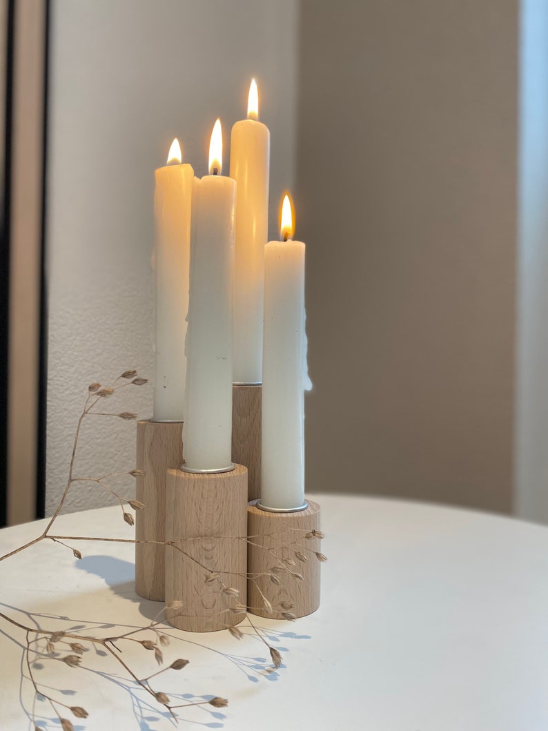 May include: A set of four white candles in wooden candle holders. The candles are lit and the holders are arranged in a staggered pattern.