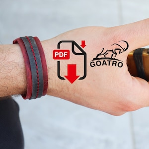 Puede incluir: Una mano con una pulsera de cuero roja y negra, un tatuaje en blanco y negro de una cabra con el texto "GOATRO" y un icono de descarga con el texto "PDF" en la palma, sosteniendo un encendedor dorado.