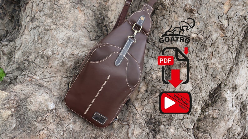 Puede incluir: Un bolso de cuero marr&oacute;n cruzado con una correa y un cierre de metal. El bolso est&aacute; sentado en un tronco de &aacute;rbol. La imagen tambi&eacute;n incluye un logotipo para Goatro, un icono de descarga de PDF y un icono de video de YouTube.