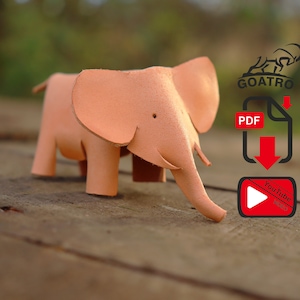 Peut inclure: Figurine d'éléphant en cuir marron clair, avec de grandes oreilles et une trompe, posée sur une surface en bois. L'image comprend également un logo, une icône PDF et une icône YouTube.