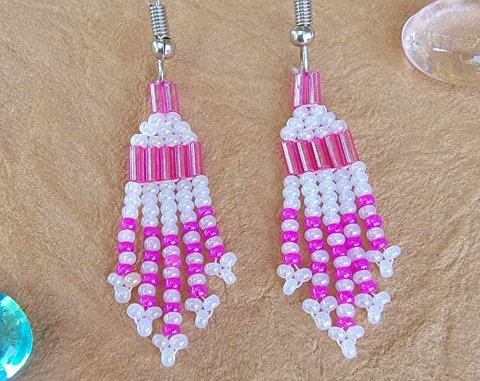 Small, short fringed, handmade, beaded pierced earrings in a variety of soft pink, bright pink, purple, black, and crystal colors.