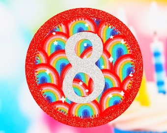 May include: A red circle with a glittery border and a white number 8 in the center. The background of the circle is a pattern of colorful rainbows.