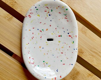 White oval clay soap dish,with colorful flecks,and drainage hole,self draining,bathroom,kitchen.