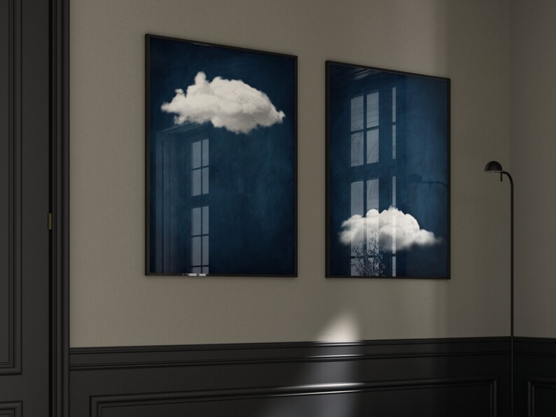 Op de afbeelding: Twee ingelijste prints met een donkerblauwe achtergrond en witte wolken. De wolken bevinden zich op verschillende posities op elke print.