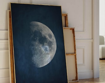 Peut inclure: Une impression encadrée d'un croissant de lune dans un ciel bleu foncé. La lune est de couleur gris clair et a une surface texturée.
