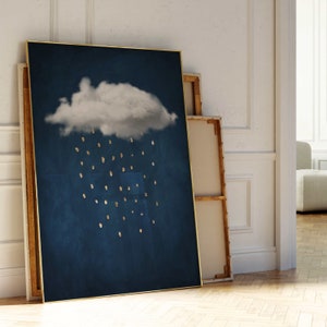 Peut inclure: Une impression d'art abstrait encadrée avec un nuage blanc et des gouttes de pluie dorées sur un fond bleu foncé.