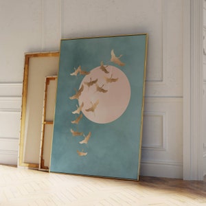 以下が含まれることがあります： 中央に大きなピンク色の円があり、その周りを金色の鳥が群れで飛んでいる、ターコイズブルーのキャンバスプリントです。