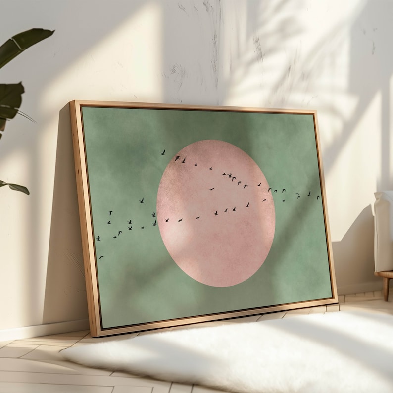 May include: A framed canvas print with a green background and a large pink circle in the center. A flock of black birds flies in a curved line across the canvas.