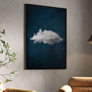 May include: A framed print of a single white cloud against a dark blue background.