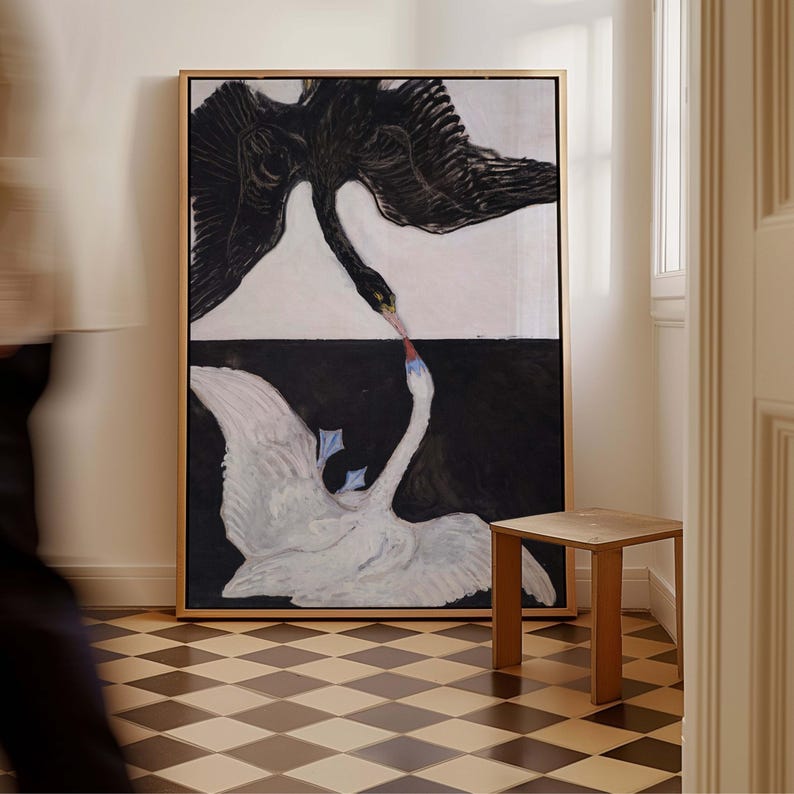May include: A painting of two swans, one black and one white, facing each other with their necks intertwined. The black swan is flying with its wings spread, while the white swan is swimming with its wings outstretched. The painting is divided into two sections, one white and one black, with a thin line separating them.
