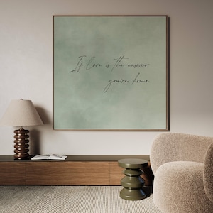 May include: A green canvas print with the text "If love is the answer, you're home" in black cursive writing.