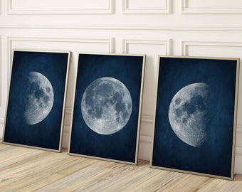 May include: Three framed prints of the moon in different phases on a dark blue background. The moon is white and has a textured surface.