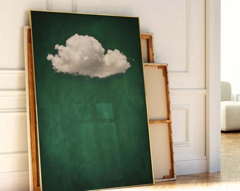 May include: A framed canvas art print featuring a white cloud against a deep green background. The artwork has a gold frame and is leaning against a wall. The overall theme is modern art.