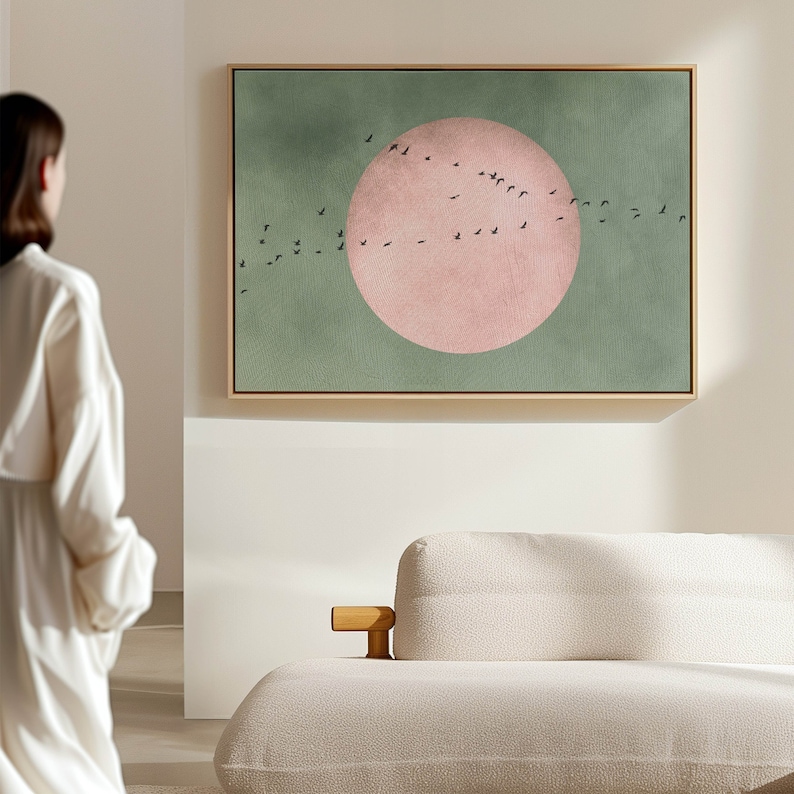 May include: A framed abstract painting with a large pink circle and a flock of black birds flying in a curved line across a green background.