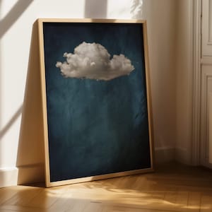May include: A framed print of a single white cloud against a dark blue background. The cloud is in the upper centre of the image.