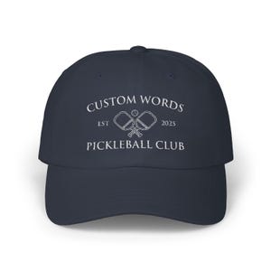 Custom pickleball hat embroidered with your team of clubs name. Features pickle ball paddles and the year.