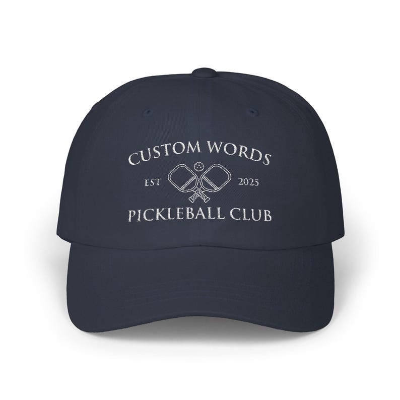 Custom pickleball hat embroidered with your team of clubs name. Features pickle ball paddles and the year.
