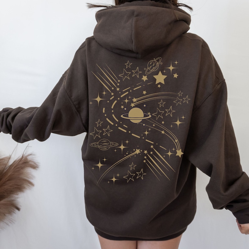May include: A brown hoodie with a gold print of stars, planets, and shooting stars on the back.