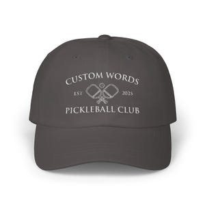 Custom pickleball hat embroidered with your team of clubs name. Features pickle ball paddles and the year.
