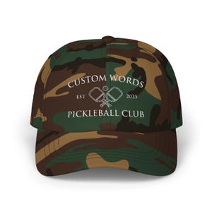 Custom pickleball hat embroidered with your team of clubs name. Features pickle ball paddles and the year.