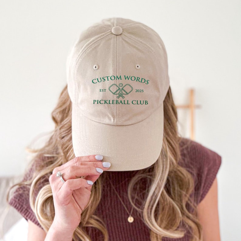Custom pickleball hat embroidered with your team of clubs name. Features pickle ball paddles and the year.