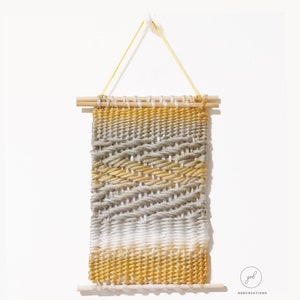 Small rectangular white, yellow and gray tapestry