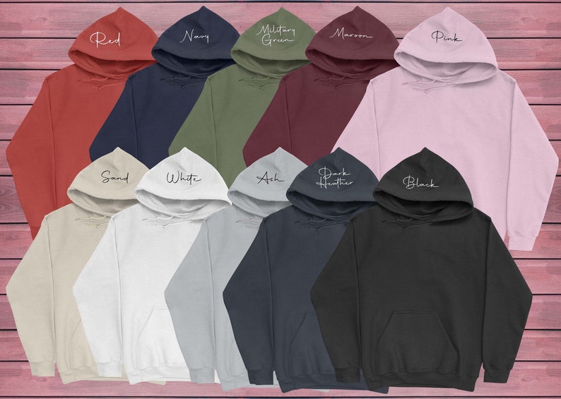 Op de afbeelding: Een assortiment aan hoodies in verschillende kleuren, waaronder rood, marineblauw, legergroen, bordeauxrood, roze, zand, wit, as, donker grijs en zwart. Elke hoodie heeft een andere kleur en een wit tekstlabel aan de voorkant.