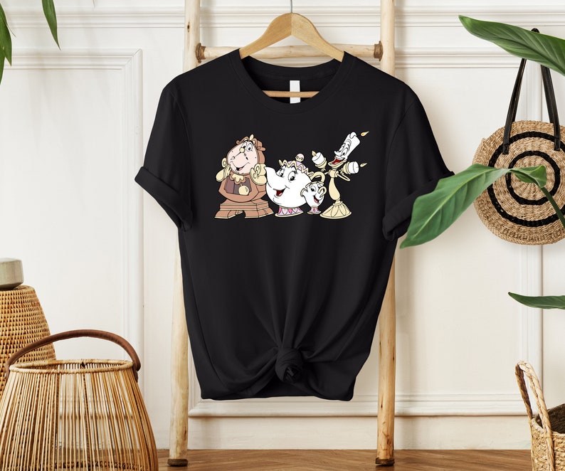 May include: Black t-shirt with a graphic print of the characters from Beauty and the Beast: Cogsworth, Mrs. Potts, and Lumiere.