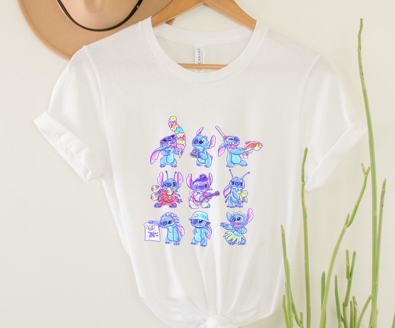 K&ouml;nnte beinhalten: Wei&szlig;es T-Shirt mit einem farbenfrohen Aufdruck der Figur Stitch in verschiedenen Posen. Der Aufdruck zeigt Stitch mit einer Kamera, Gitarre spielend und mit einem Hula-Rock. Das T-Shirt besteht aus einem weichen, leichten Material.
