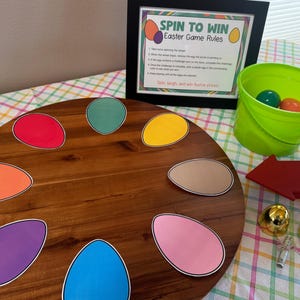 May include: A wooden spinning wheel game with colorful egg-shaped pieces. The game is called "Spin to Win Easter Game Rules".
