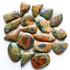 May include: A collection of 15 green, brown, and orange ocean jasper cabochons. The cabochons are various shapes and sizes, with some having a more rounded shape and others having a more pointed shape.