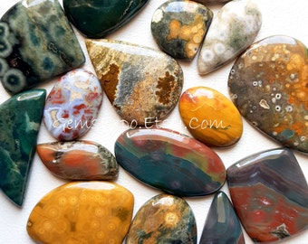 May include: A collection of polished gemstones in various shapes and sizes. The stones display a range of colors, including greens, browns, yellows, and reds, with unique patterns and textures. Some stones have a smooth, glossy finish, while others appear more matte.