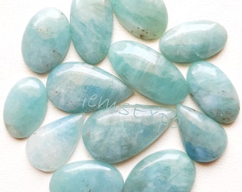 May include: A collection of 12 aquamarine cabochons, each with a unique, natural pattern and a light blue color. The cabochons are oval-shaped and have a smooth, polished finish.