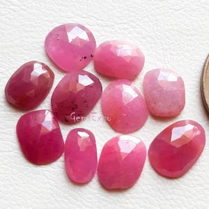 Könnte beinhalten: Eine Sammlung facettierter, ovaler und runder rosa Edelsteine. Die Edelsteine variieren in Rosatönen, von hell bis tief. Das Bild enthält den Text "GemsExpo".