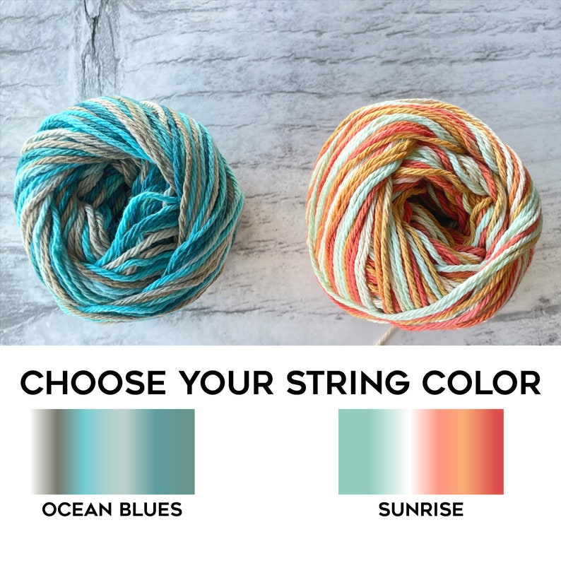 May include: Two balls of string, one in ocean blue and beige stripes and one in orange, yellow, and white stripes. Choose your string color: Ocean Blues or Sunrise.