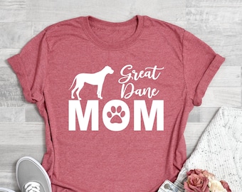 May include: Coral pink t-shirt with a white Great Dane silhouette and the text "Great Dane Mom" with a paw print in the "O".