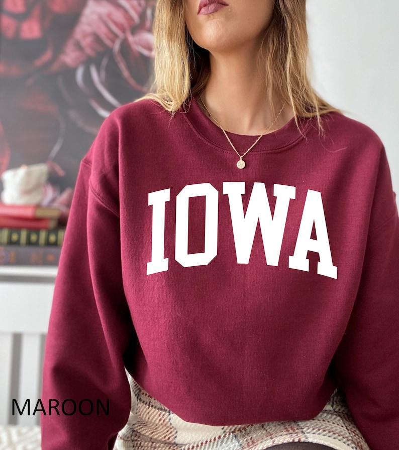 May include: Maroon sweatshirt with the word "IOWA" in white block letters.