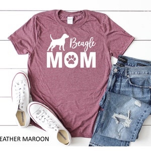 Op de afbeelding: Heather-marronkleurig T-shirt met een wit silhouet van een beagle en de tekst "Beagle Mom" met een pootprint.