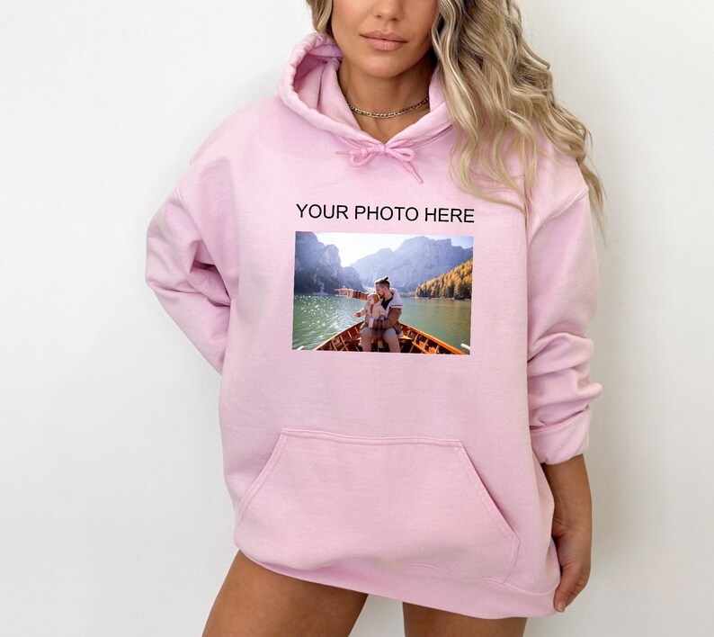 May include: Pink hoodie with a pocket and a photo of a couple on a boat printed on the front. The text "YOUR PHOTO HERE" is printed above the photo.