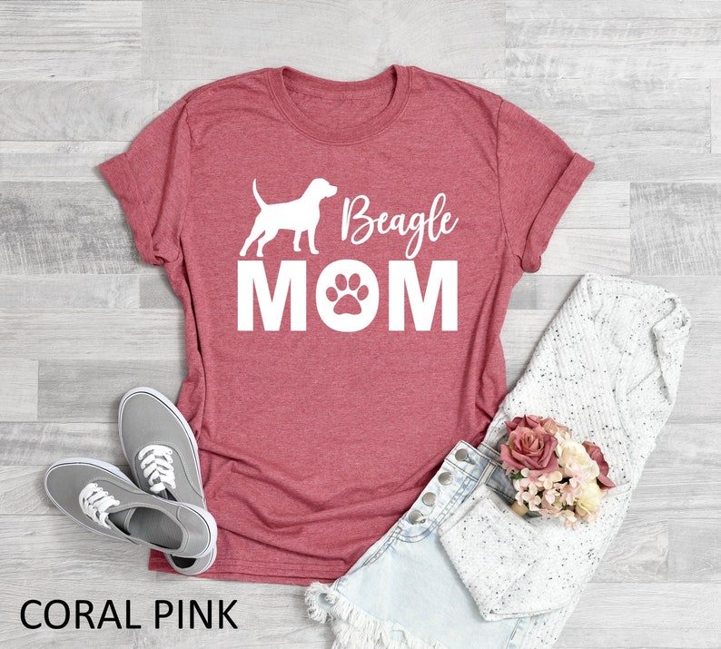 Op de afbeelding: Koraalroze T-shirt met een wit silhouet van een beagle en de tekst "Beagle Mom" met een pootprint.