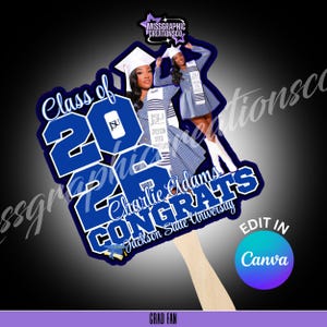 Op de afbeelding: Een afstudeerwaaier met een blauw en wit ontwerp met de tekst "Class of 2026" en "Congrats Charlie Adams Jackson State University." De waaier bevat afbeeldingen van een afgestudeerde in toga en baret. De handgreep is van hout.