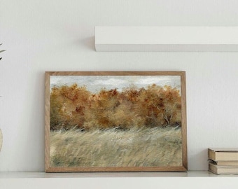 May include: A rectangular landscape painting in a wooden frame featuring a field of tall, light-coloured grasses in the foreground and a dense line of trees with warm, golden-brown autumn foliage under a cloudy, overcast sky.