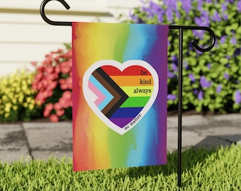 May include: A rainbow-colored garden flag with a white heart in the center. The heart features a pride flag with the text "be kind always no matter."