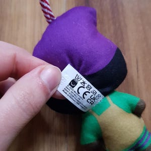 May include: Purple, black, green, and yellow plush toy with a tag that reads "2022 McDonald's, HAVI, SE18DJ, UK, CE, UK, CA, HAVI 47228 Duisburg Germany, Made in Vietnam TDM 25882-7".