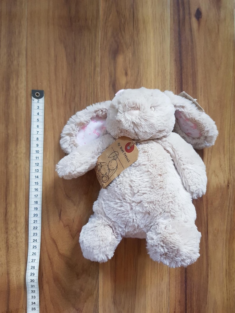 May include: A soft, beige bunny toy with long, floppy ears, showing a pink floral pattern inside. The toy has a tag that reads "My Best Friend". The bunny is approximately 30 cm tall.