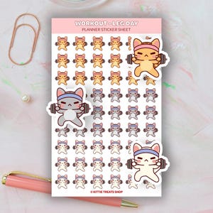 May include: Planner sticker sheet featuring cartoon cats lifting weights. The sheet includes the text "WORKOUT - LEG DAY PLANNER STICKER SHEET" at the top. The stickers are in shades of orange, gray, and white, with blue headbands. The stickers are from Kittie Treats Shop.
