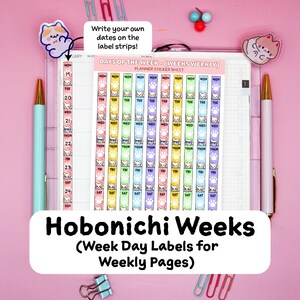 May include: A planner sticker sheet featuring vertical strips with days of the week and cat illustrations in various colors. The text reads DAYS OF THE WEEK - (WEEKS WEEKLY) PLANNER STICKER SHEET. The sheet is placed on a planner page with a light blue pen and a white pen on either side, alongside colorful paper clips and cat-shaped decorative clips.